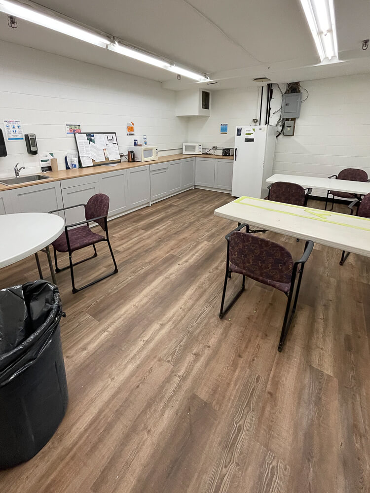 spotless and clean office kitchen with beige tables and burgundy office chairs