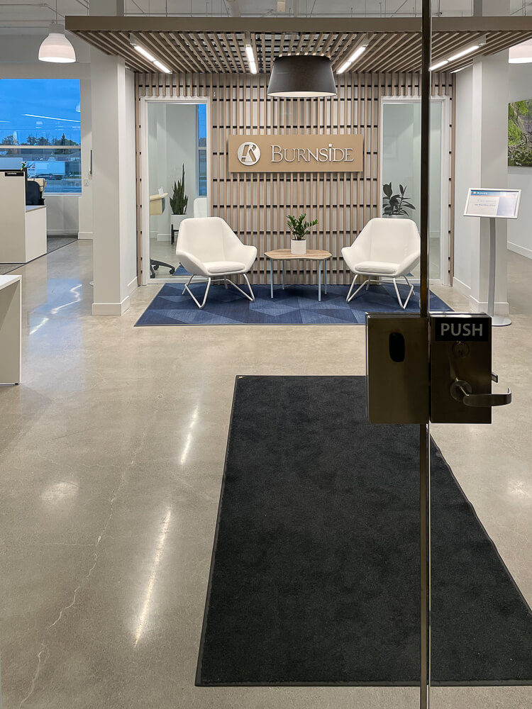 A foyer of an office space with a black floor mat. Clean floors